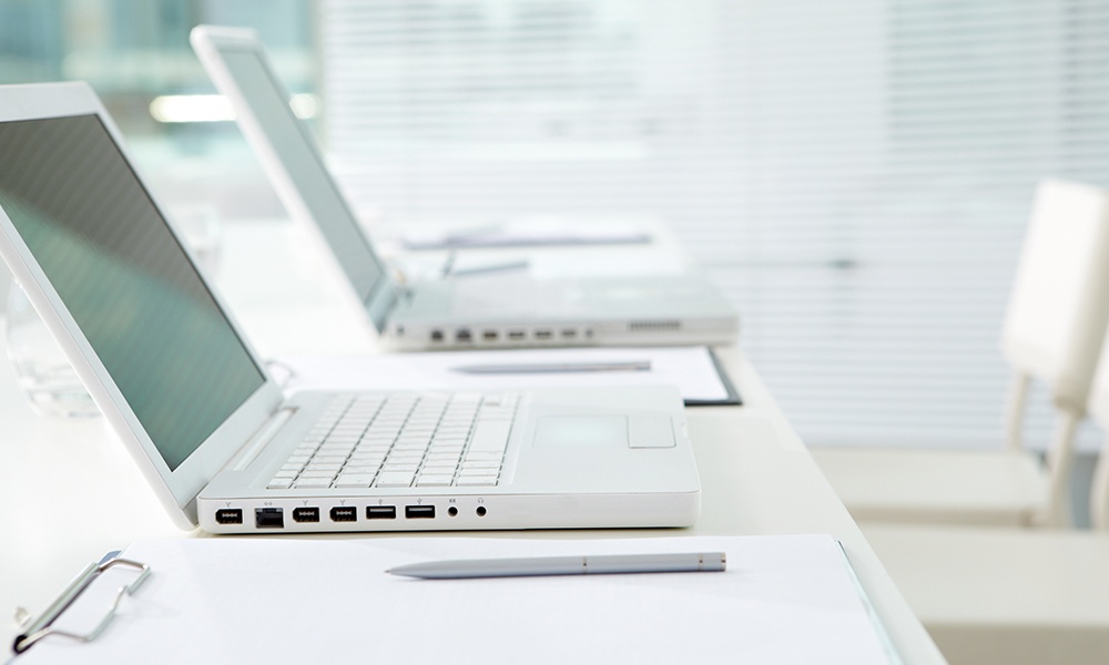 How a PEO Can Support in Hiring and Managing Remote Employees - Close-up of a Two Laptops in an Office