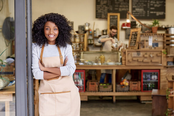 4 Pain Points for the Small Business Owner - Friendly Business Owner Standing in Front of Her Shop